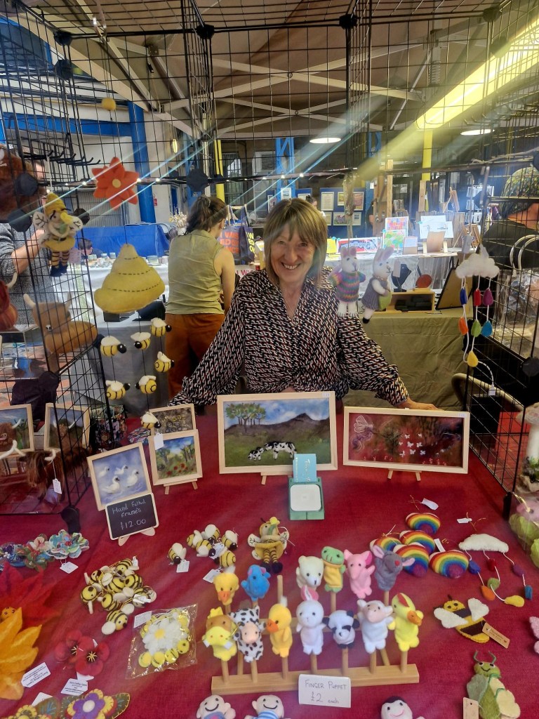 a picture of sue in front of a table with her crafts